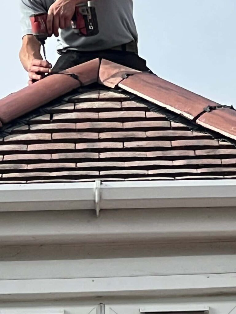 This is a photo of one of the operatives of Fareham Roofing Repairs installing new ridge tiles