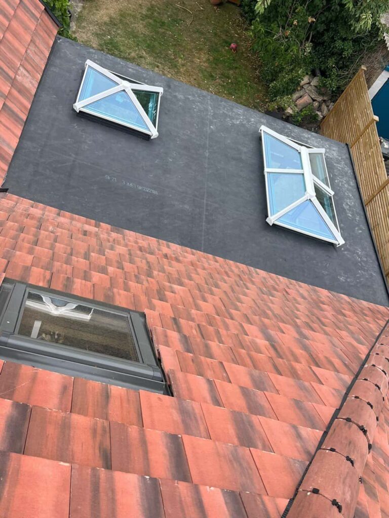 This is a photo taken from the roof ridge looking down a tiled pitched roof on to a flat roof. Works carried out by Fareham Roofing Repairs